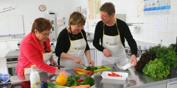 3 Personen beim Gemüse schneiden