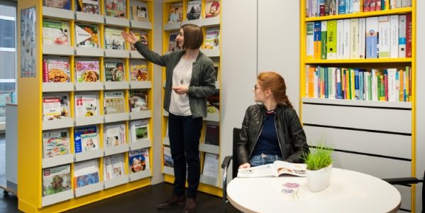 2 Frauen vor einem Bücherregal